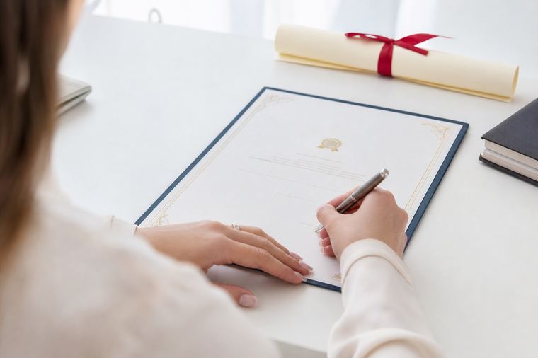Scrivania di una segreteria didattica con un documento di fine corso pronto da controllare.