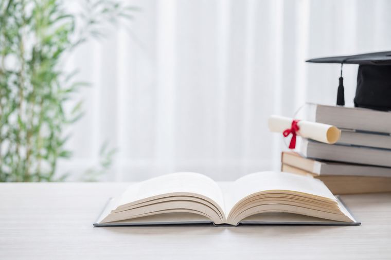 Libro aperto accanto a una tazza fumante, immagine del glossario della formazione accreditata.